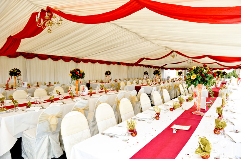 A colourful marquee with large dining areas to seat groups of 16 to 20 wedding guests.