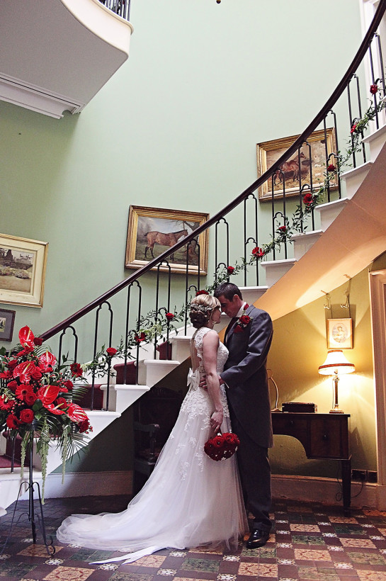 A chain of tied red roses on the cantilevered staircase provide a wonderful romantic touch at a wedding.